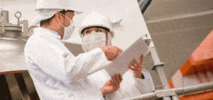 employees looking at clipboard during quality check at factory photo for FSMA article