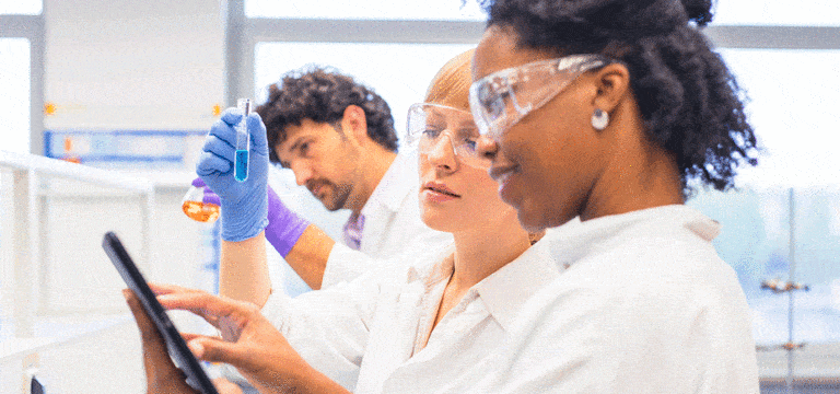 two scientists looking at a vial for photo for ind submission article