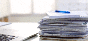 photo of a stack of papers with a pen on top next to a computer for due diligence case study