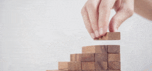 person stacking wooden blocks for project portfolio management article