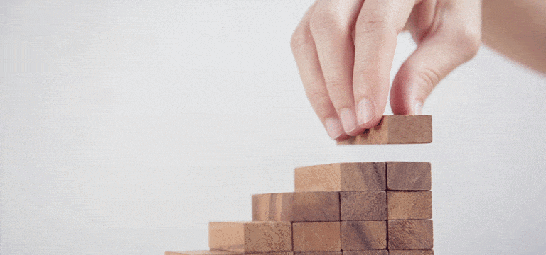 person stacking wooden blocks for project portfolio management article