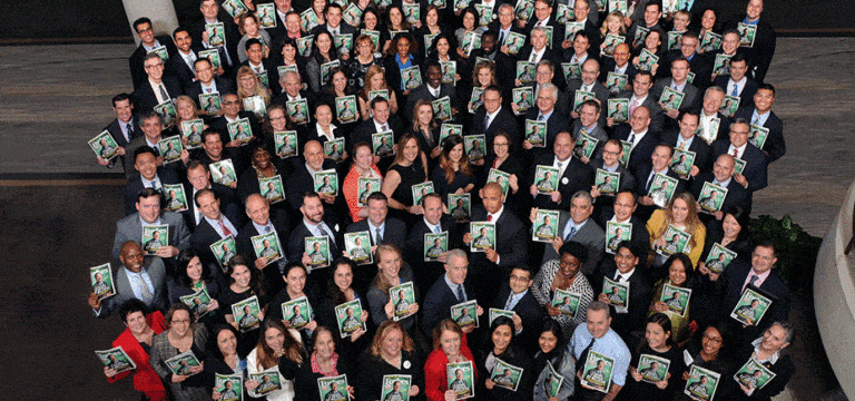 Group photo of IPM employees holding Forbes magazine