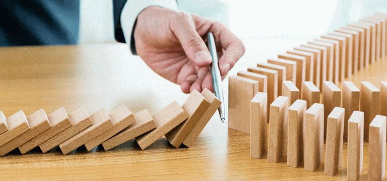 person stopping change in domino directions to keep them from falling over