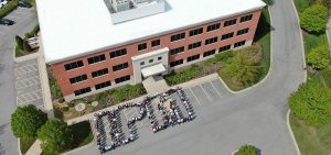 photo of new IPM headquarters building with employees standing in front of building spelling out IPM