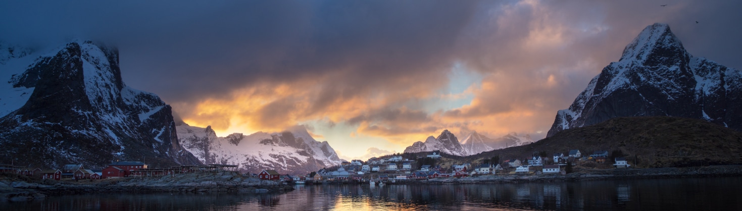 A small town on a lake at the bottom of a mountain range