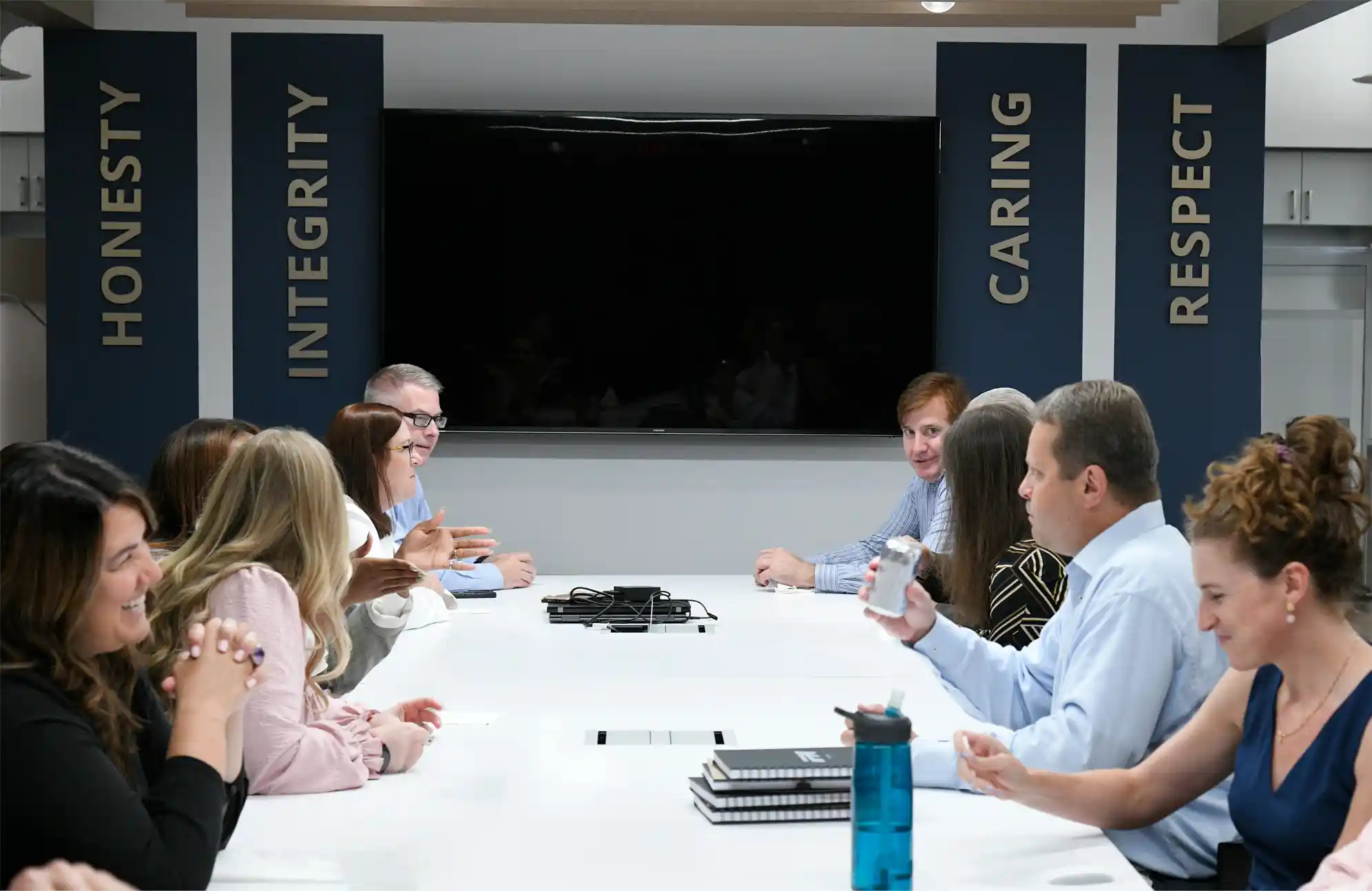 Company board meeting with pillars reading 'Honesty, Integrity, Caring, and Respect'