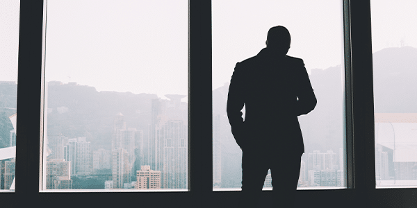 Entrepreneur in suit standing indoors in loft interior contemplating his business' culture